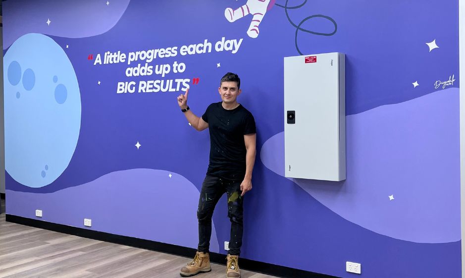 Diegodalo with the finished A little progress each day adds up to big results mural at Tutors SA