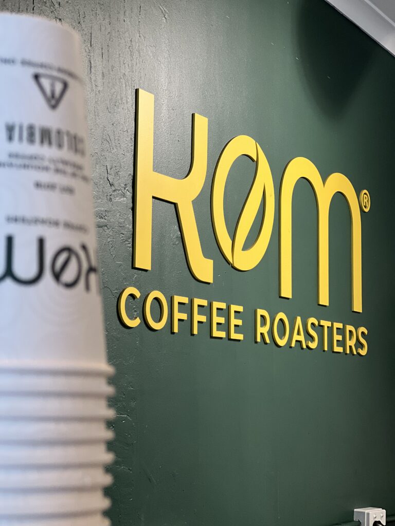 Close-up of the hand-painted 3mm MDF KOM Coffee Roasters lettering