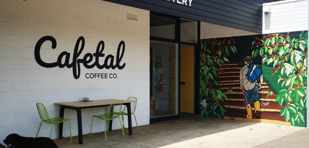Cafetal Coffeeco shopfront in Kent Town with the hand-painted logo, yellow door and Colombian coffee mural by Diegodalo