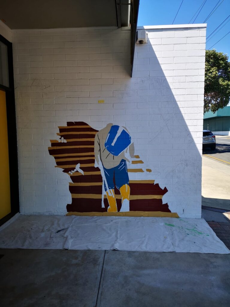 The Cafetal Coffeeco mural in progress, with the first layers of the coffee farmer and bamboo steps painted