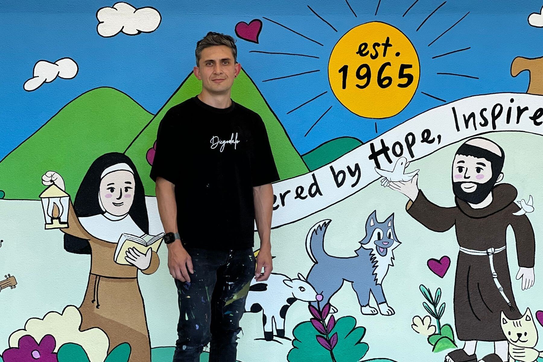 Diegodalo in front of a completed school mural