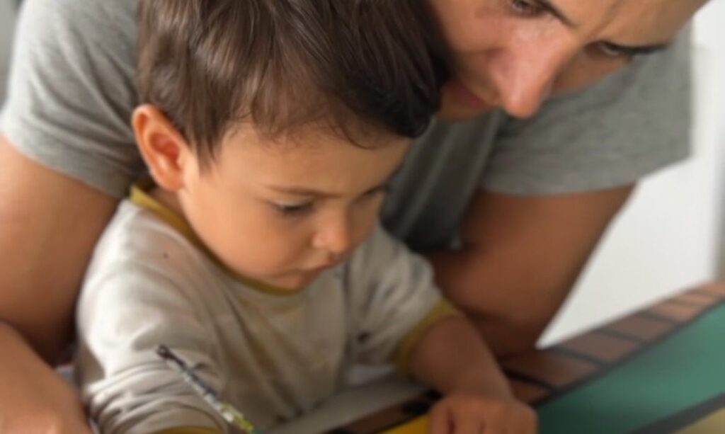 Diego painting the Stirling North mural panels in the studio with his son