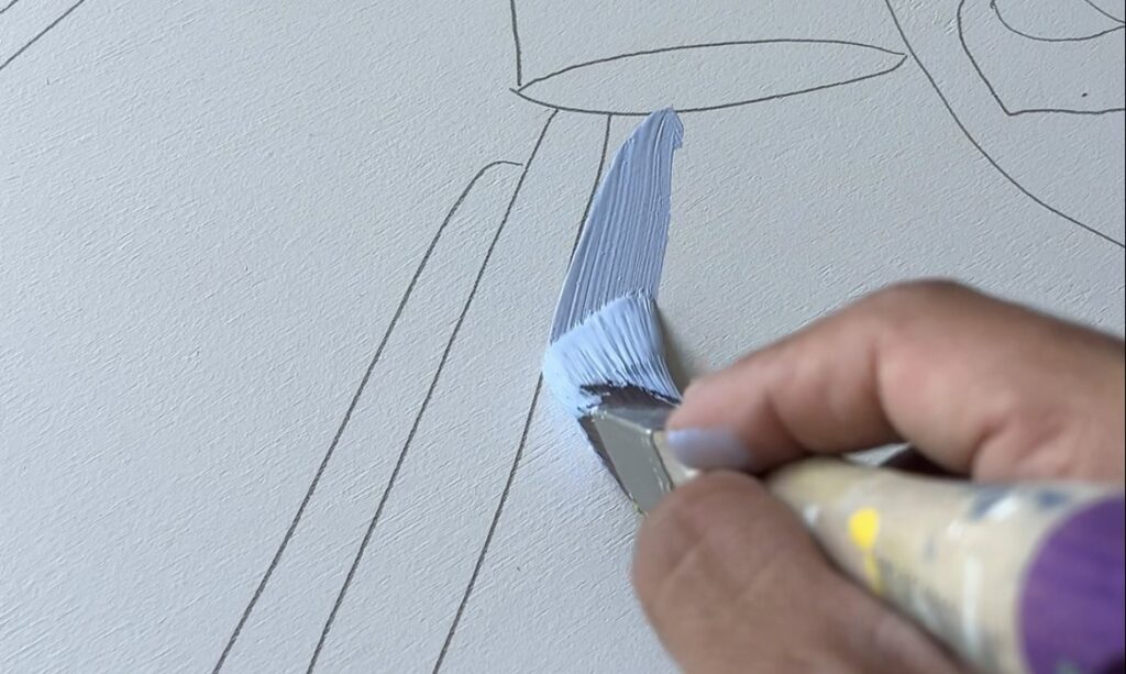 Diego applying the first light blue brushstroke over the pencil sketch on the Stirling North mural panels