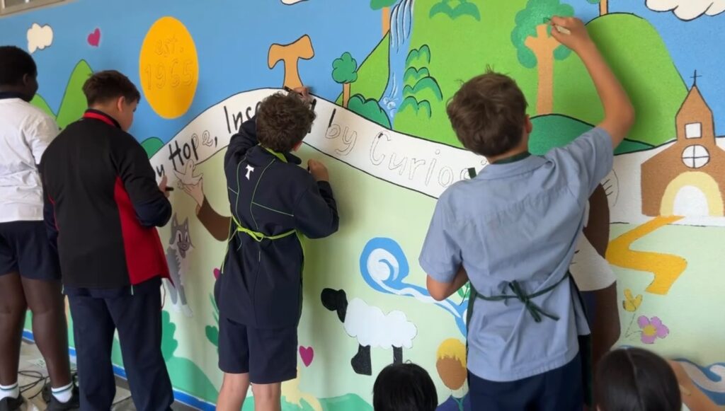 Older students painting the St Francis of Assisi School mural