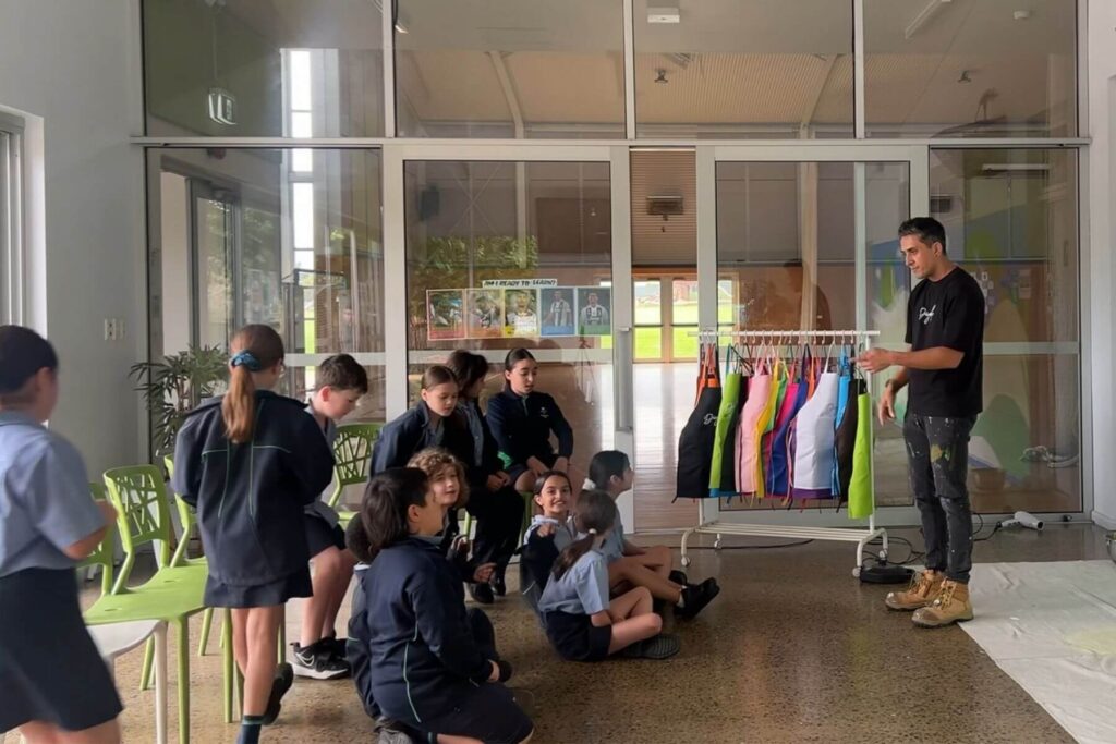 2 Students listening during a school mural workshop introduction