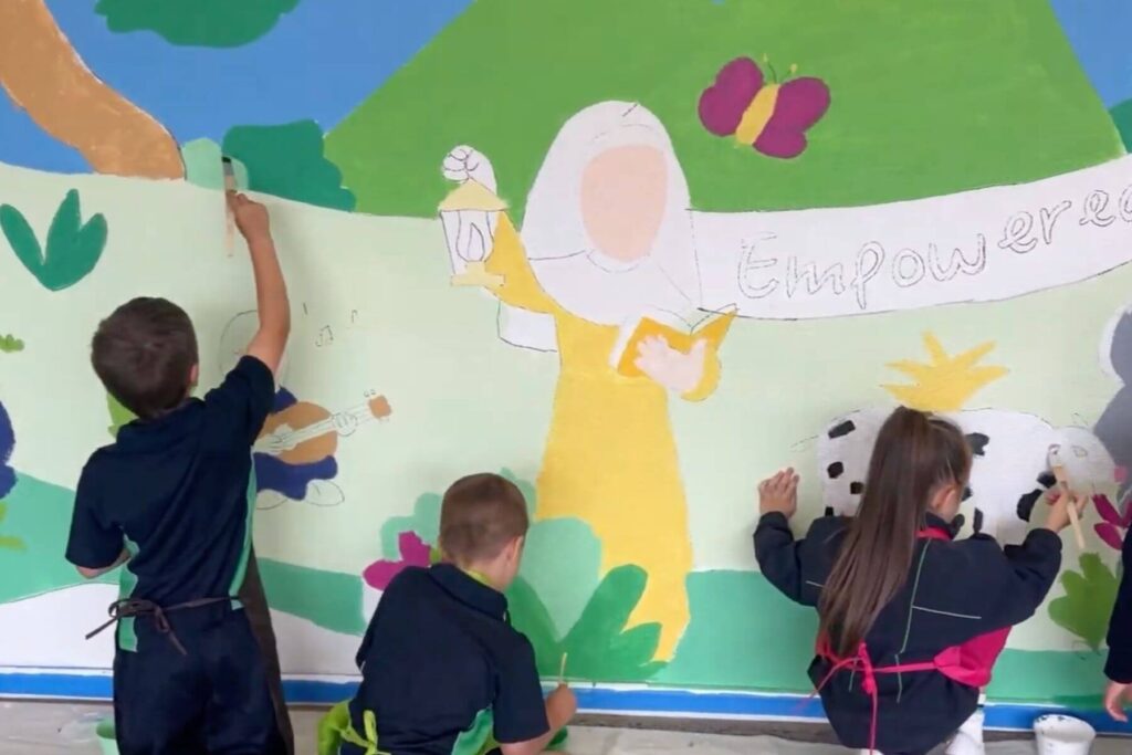 Primary school students painting a mural during a workshop