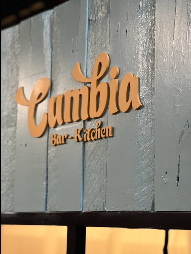 Dimensional Cumbia Bar Kitchen logo sign mounted on the painted timber stall at Adelaide Central Market