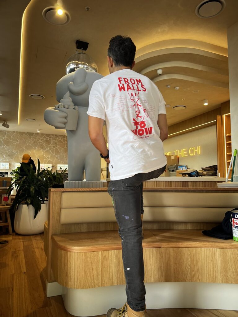Diegodalo standing beside the blank Yo-Chi Bear sculpture at Yo-Chi Prospect before painting